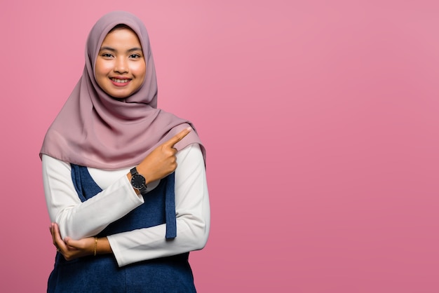 Young asian woman smiling and pointing to side