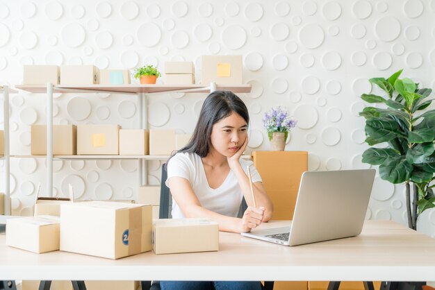 Giovane donna asiatica avviare piccolo imprenditore che lavora con tavoletta digitale sul posto di lavoro.