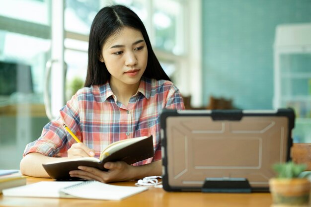 Photo young asian woman study in front of the laptop computer and at offsite