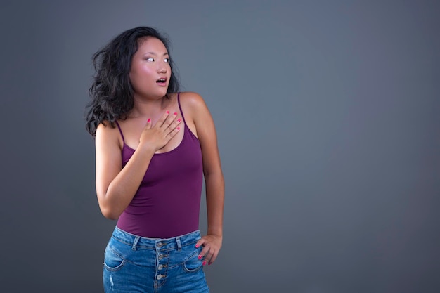 Young asian woman in tank top with funny expression isolated from the background