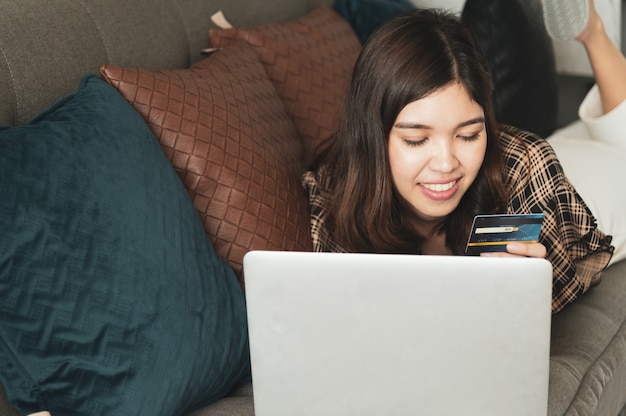 Foto giovane donna asiatica utilizzando la carta di credito per lo shopping online