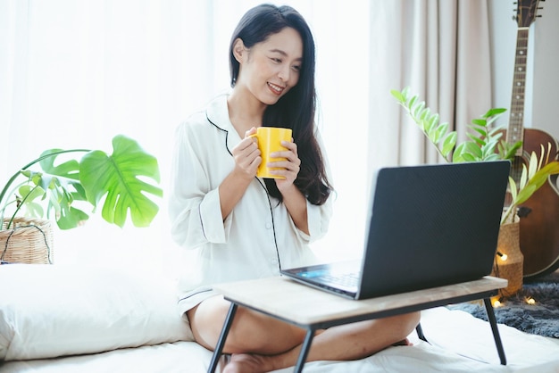 비즈니스 온라인 작업에 랩톱 컴퓨터를 사용하는 젊은 아시아 여성 사업가 직업을 위해 인터넷 사이버 공간 통신 기술을 사용하여 집에서 일하는 여성 프리랜서