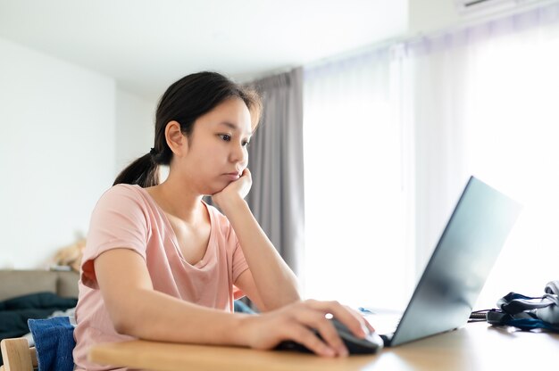 Young asian woman using laptop at house Work at home