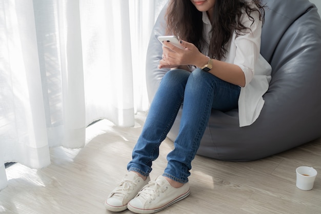 young asian woman using mobile in living room at home