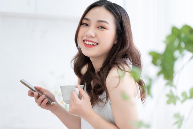 Young Asian woman using smartphone at home in the morning