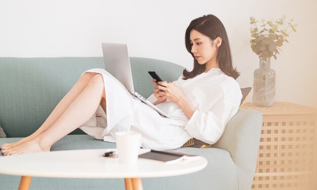 Photo young asian woman using smartphone at home