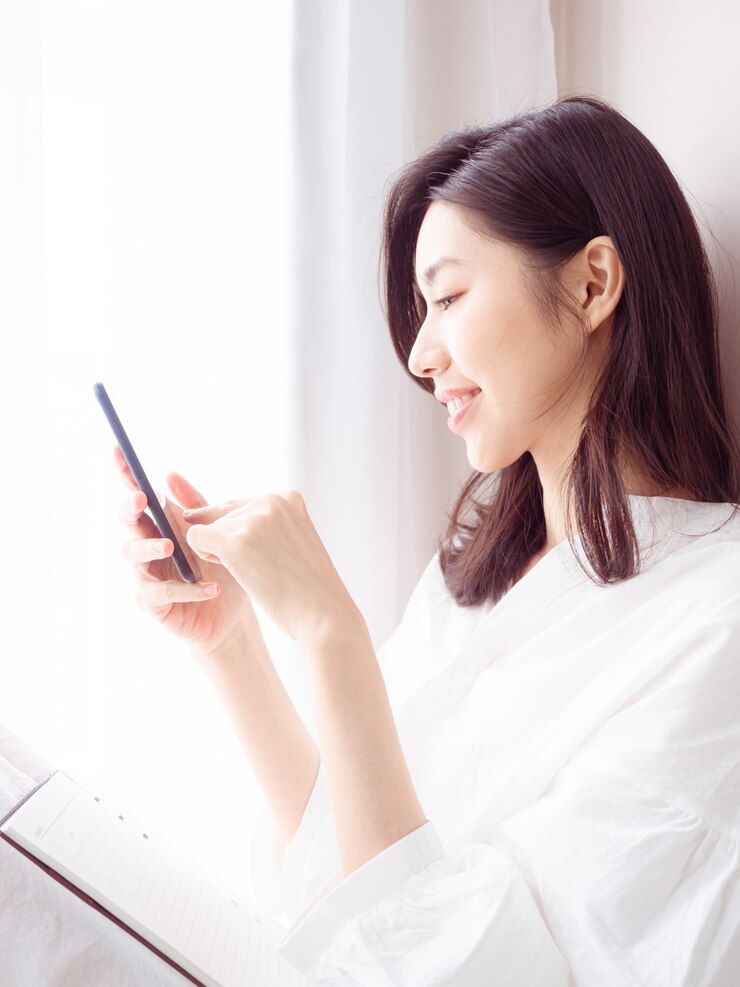 Photo 自宅でスマートフォンを使用して若いアジアの女性