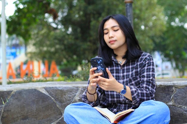 young asian woman using smartphone in outdoor urban area to browsing surfing and online shopping