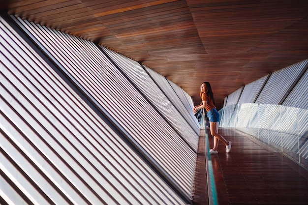 A young asian woman walking inside a modern wooden building