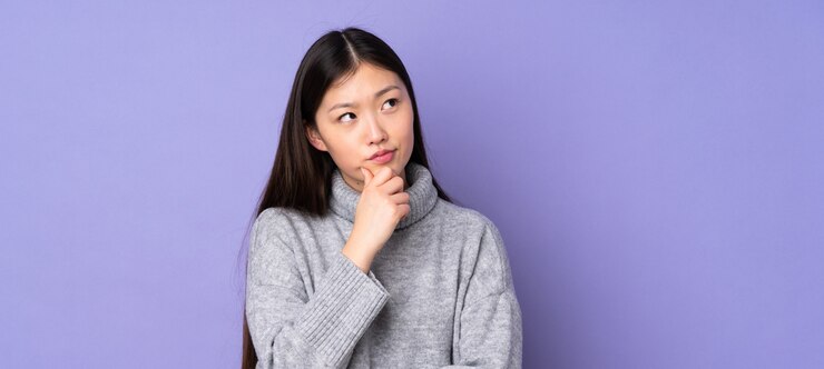 의심은 데 벽에 젊은 아시아 여자