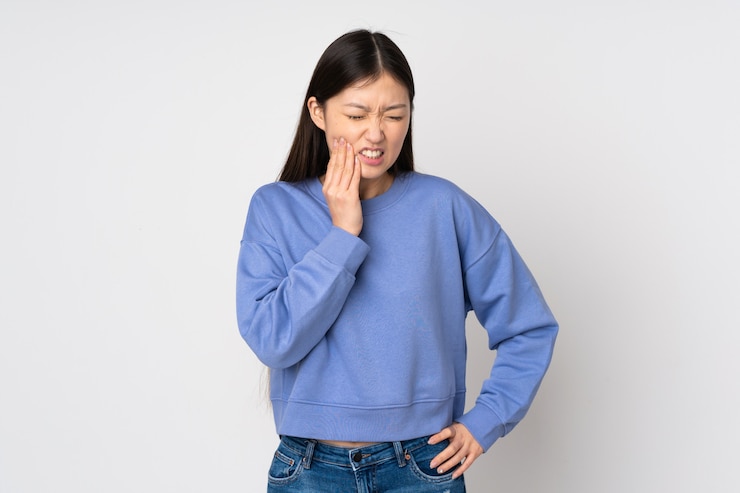 Photo 치 통으로 벽에 젊은 아시아 여성