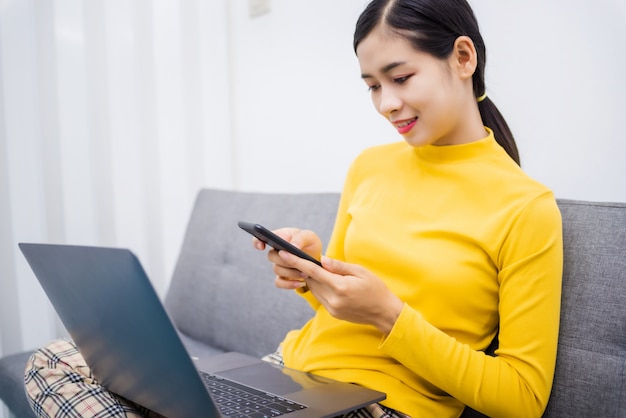 Young Asian woman watching something on mobile