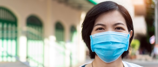 Foto giovane donna asiatica che indossa posa blu della maschera di protezione