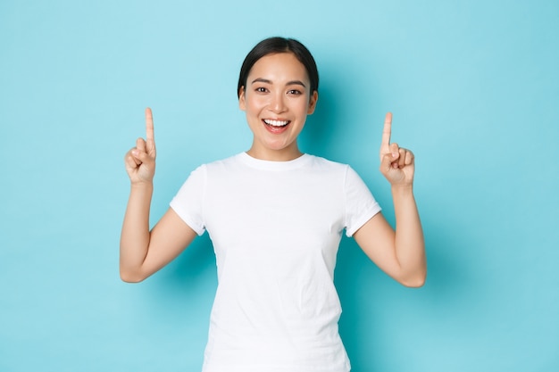 カジュアルなTシャツのポーズを着て若いアジアの女性