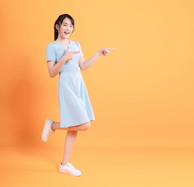 Young Asian woman wearing dress on background