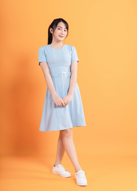 Young Asian woman wearing dress on background