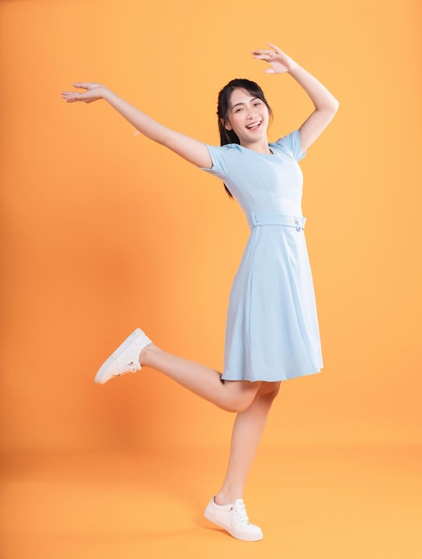 Young Asian woman wearing dress on background