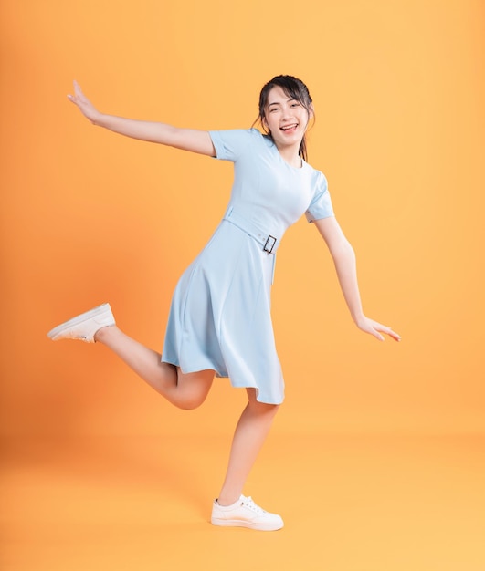 Young Asian woman wearing dress on background