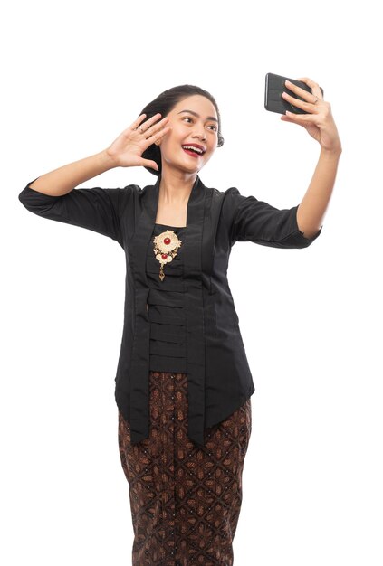 Young asian woman wearing kebaya selfie using a smartphone