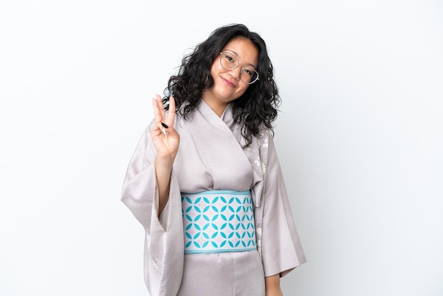 Young asian woman wearing kimono isolated on white background happy and counting three with fingers