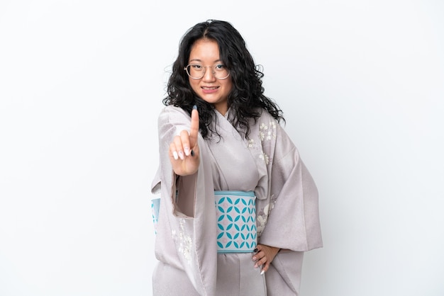 Young asian woman wearing kimono isolated on white background showing and lifting a finger