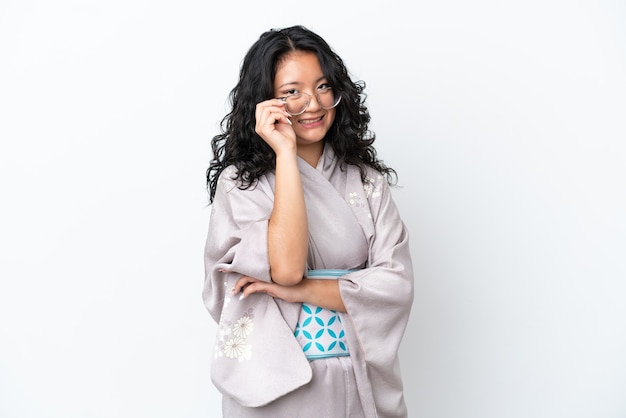 Young asian woman wearing kimono isolated on white background with glasses and happy