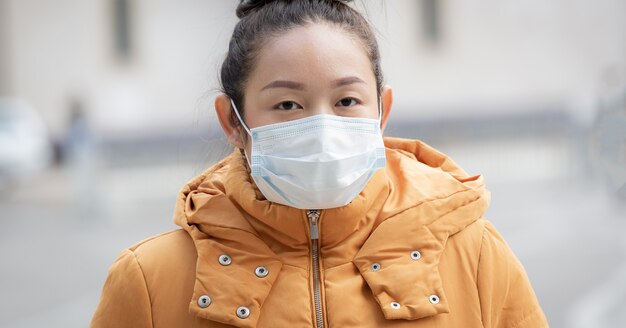 세균, 독성 연기 및 먼지를 방지하기 위해 마스크를 착용하는 젊은 아시아 여성