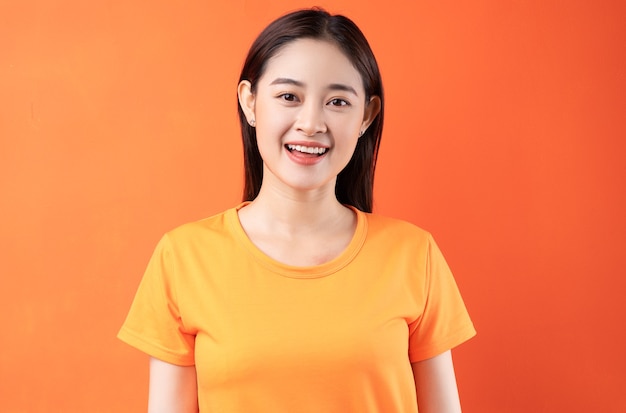 young Asian woman wearing orange t-shirt on orange