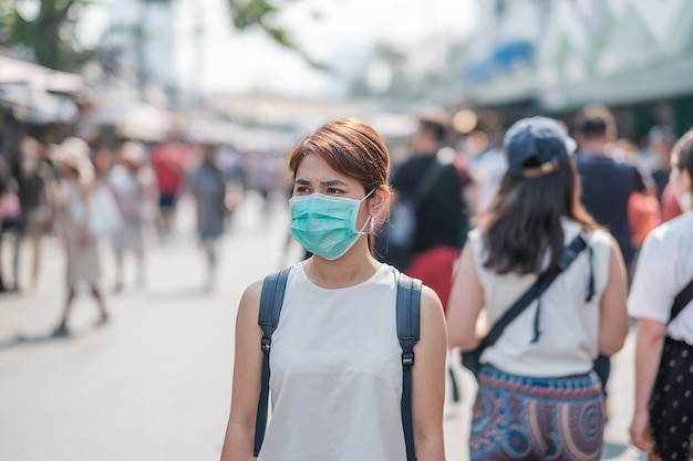 차 뚜착 주말 시장에서 소설 코로나 바이러스 (2019-nCoV) 또는 우한 코로나 바이러스에 대한 보호 마스크를 착용 한 젊은 아시아 여성