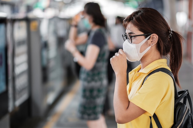 Young Asian woman wearing protection mask against Novel coronavirus (2019-nCoV) or Wuhan coronavirus at public train station,is a contagious virus that causes respiratory infection.Healthcare concept