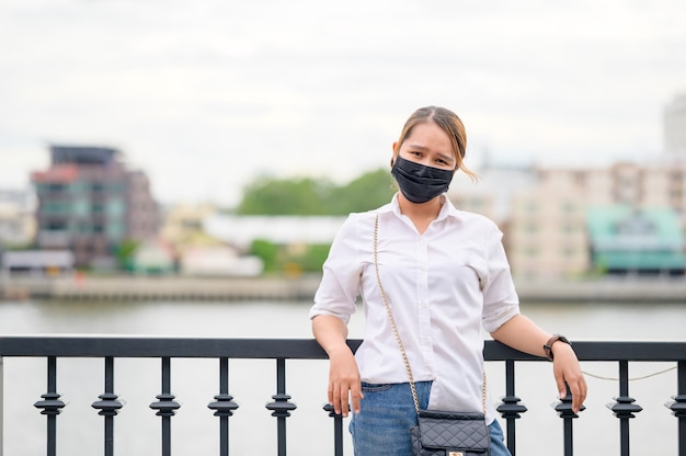 市内の細菌やウイルスの蔓延を防ぐために防護マスクを身に着けている若いアジア女性