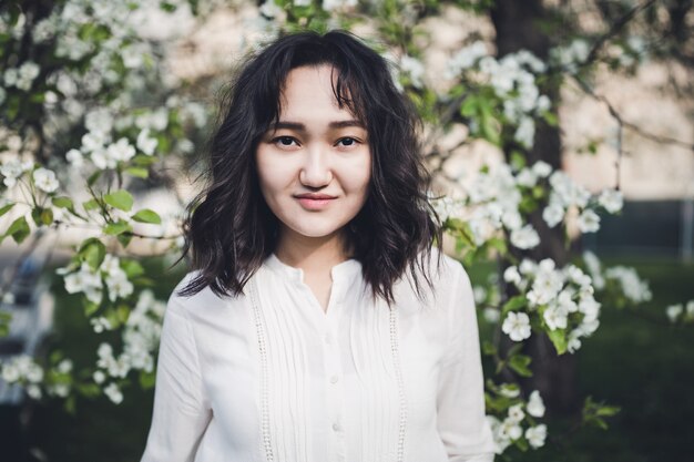 Young asian woman in a white shirt, spring portrat