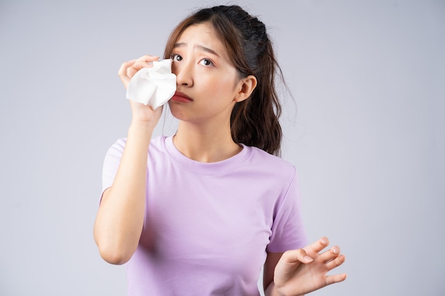 Young Asian woman wipes her tears with a tissue