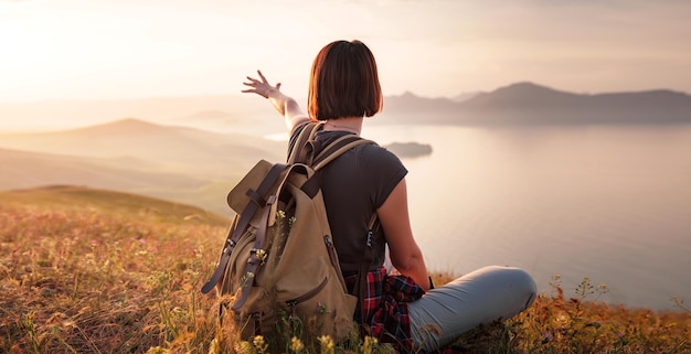 A young Asian woman with a backpack hiking in the summer