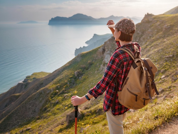 A young Asian woman with a backpack hiking in the summer