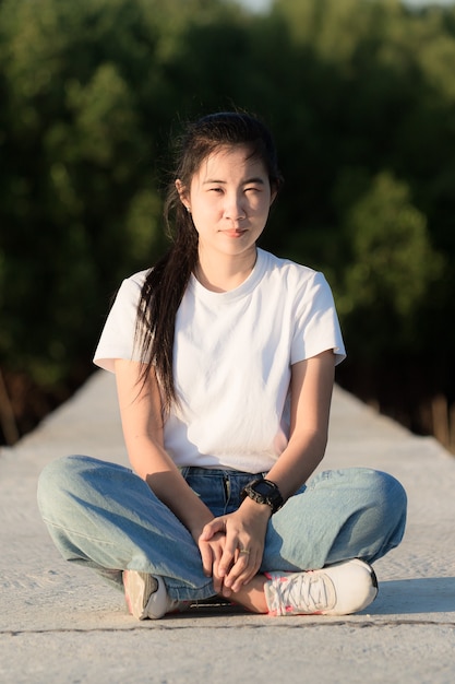 Photo young asian woman with backpack standing and looking for something in the park