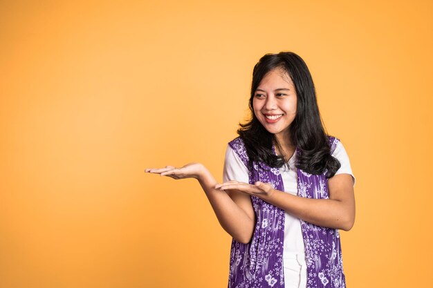 Young asian woman with hand gesture presenting something on isolated background person