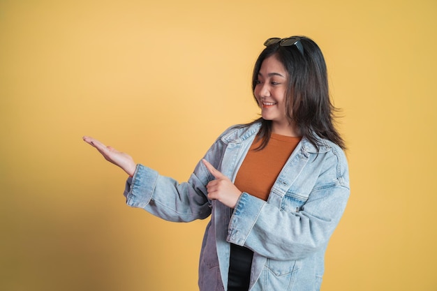 Young asian woman with hand gesture presenting something