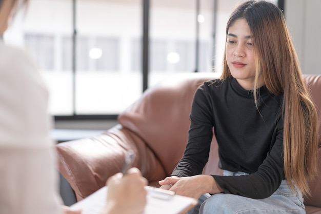 写真 メンタルヘルスに問題のある若いアジア人女性が心理学者に会い、メンタルセラピーに相談します。心理学とメンタルセラピーの概念