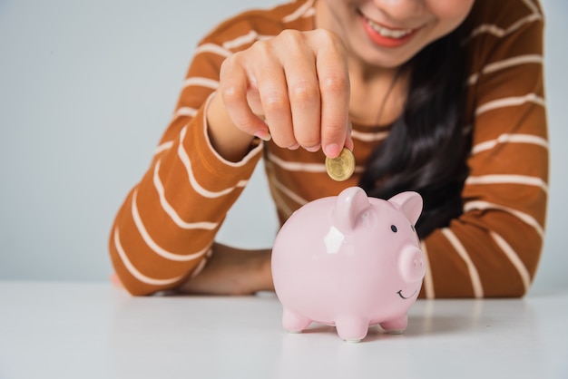 Young asian woman with money coin and piggy bank