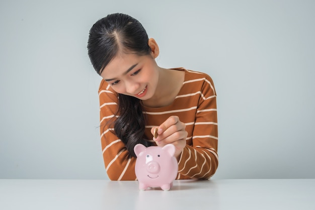 Young asian woman with money coin and piggy bank