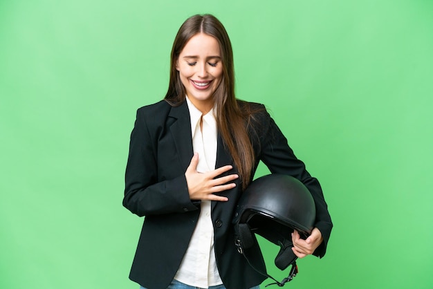 Young Asian woman with a motorcycle helmet over isolated chroma key background smiling a lot