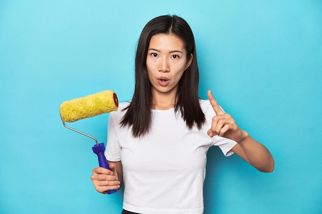 Young Asian woman with paint roller DIY concept having an idea inspiration concept