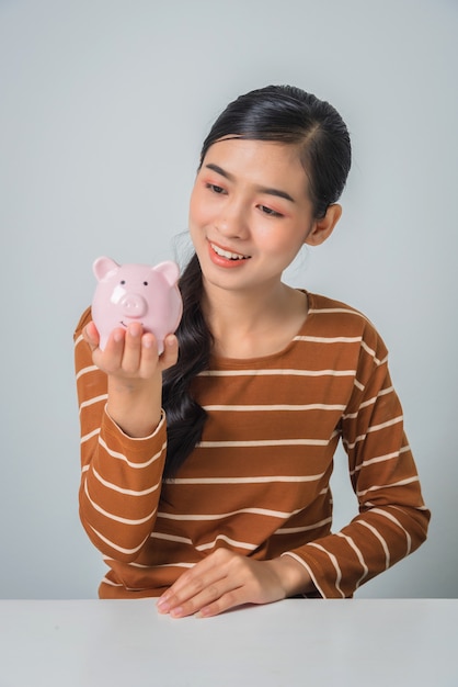 Young asian woman with piggy banks