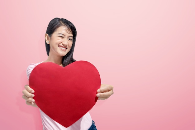 Young asian woman with red heart on her hands