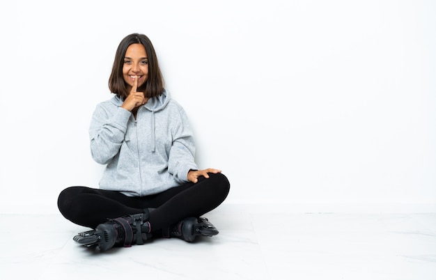 Young asian woman with roller skates on the floor showing a sign of silence gesture putting finger in mouth