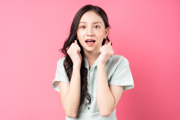 Young Asian woman with scared look on pink