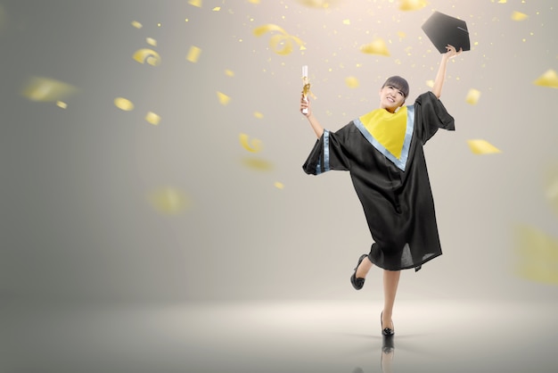 Young asian woman with scroll celebrating her graduation