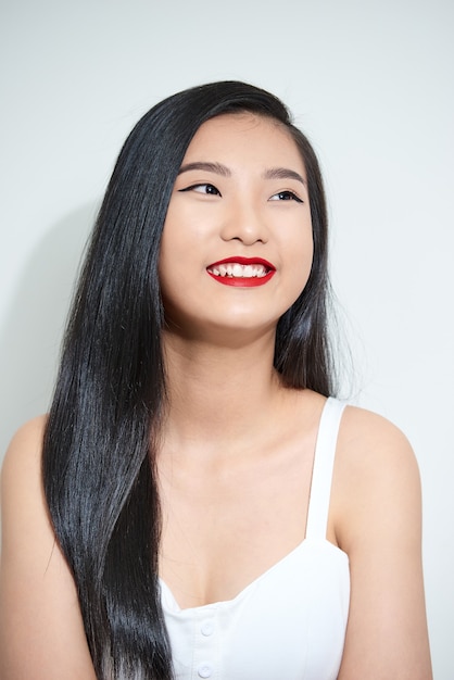 白い背景で隔離の笑顔の若いアジアの女性。