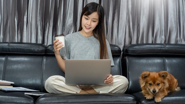 young asian woman working remotely from home and smiling